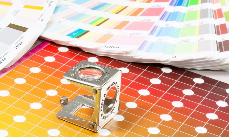 Pantone colour swatches and a loupe used for print colour matching